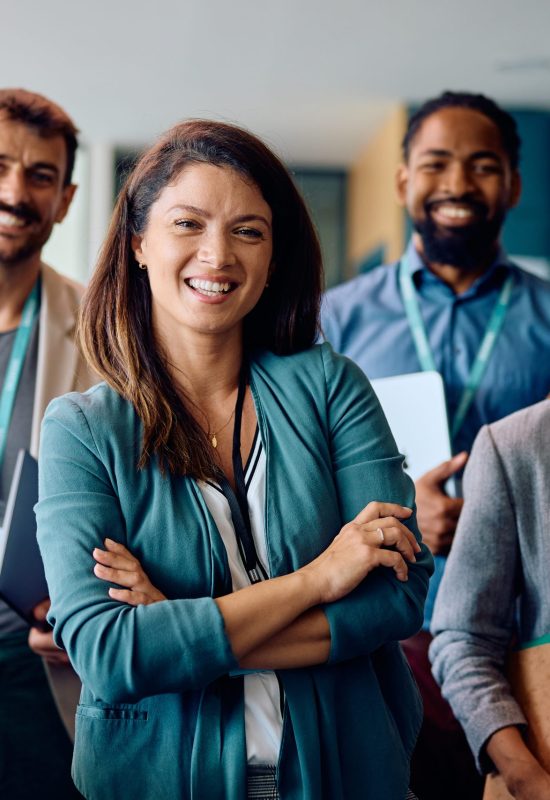 Confident CEO and her business team in the office looking at camera.